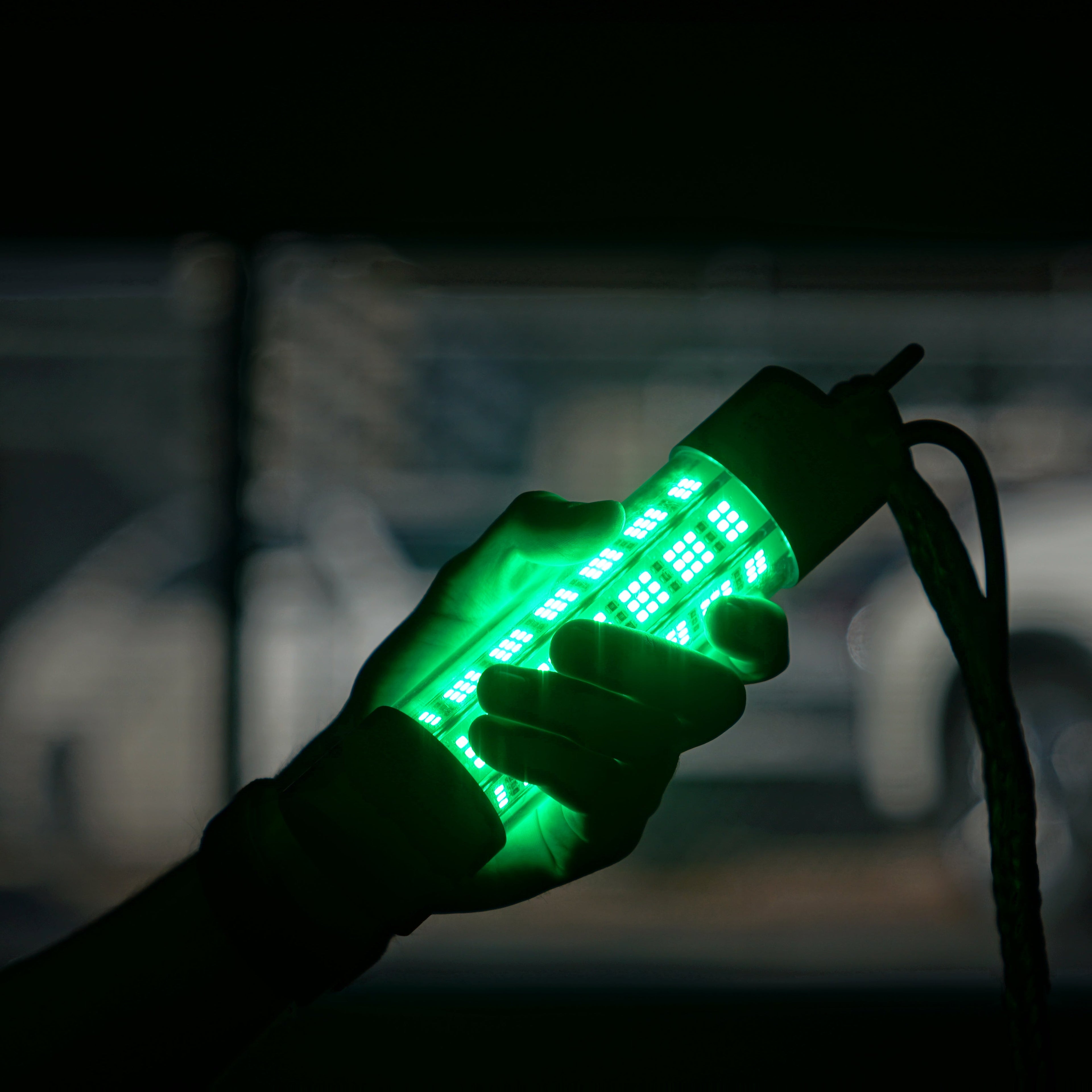Hand with green LED lights against a dark background